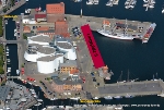 Die Stralsunder Hafeninsel. Derzeit sind Taucher dabei, die Kaikanten ab Fährbrücke (links oben im Bild) bis zur Querkanalbrücke (unterer Bildrand) unter die Lupe zu nehmen. Rot gekennzeichnet ist der Bereich, der aktuell mit einem Zaun abgesperrt ist - Liegeplatz 6.