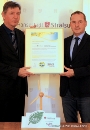 Die Stadt bekommt das Ökostromzertifikat: Tarik Kreißel von den Stadtwerken Stralsund (r.) überreicht es an Holger Albrecht, Amtsleiter für Schule, Sport und Zentrales Gebäudemanagement.