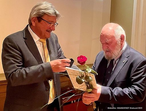 Peter Redenz (r.) erhält vom Präsidenten der Bürgerschaft, Peter Paul, die goldene Ehrennadel 
